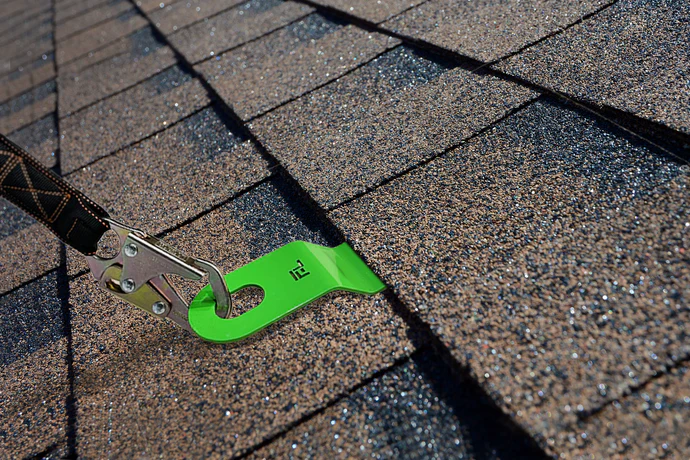 Green shingle nail on a roof with shingles in the background